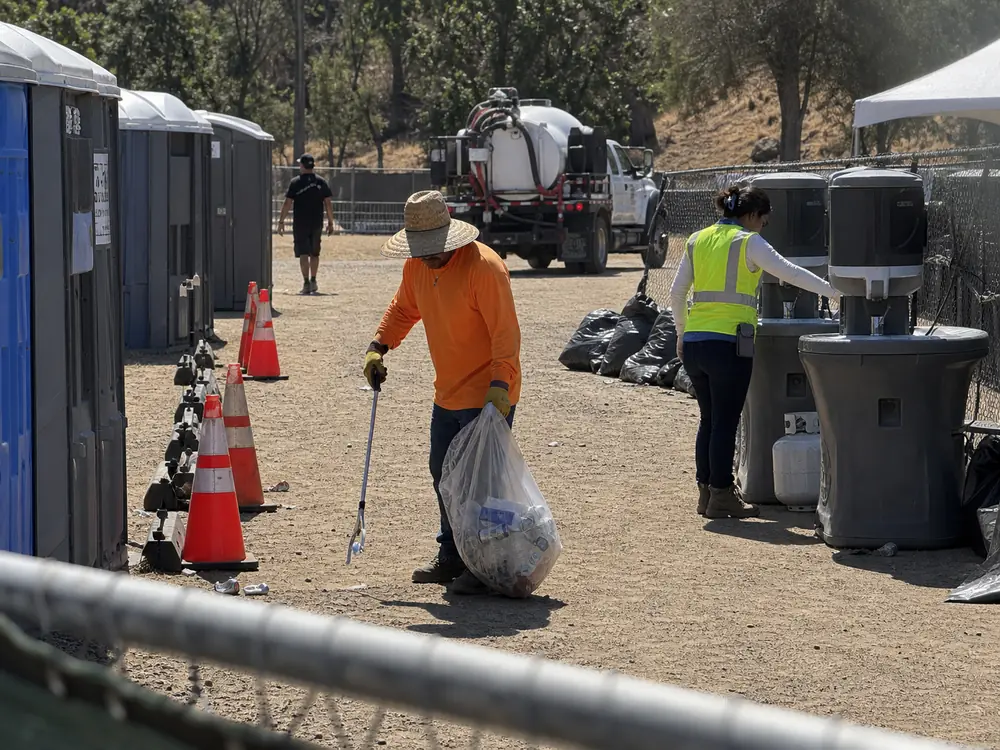 Crew checking the area around portable restrooms at a park event