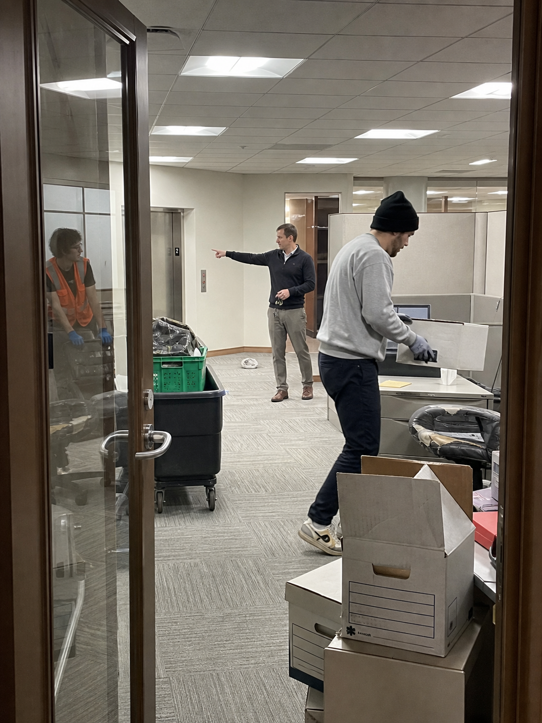 Crew clearing office furniture and boxed items during a move-out